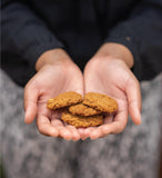 Hands holding gluten-free Coconut Oat cookie with cannabinoids